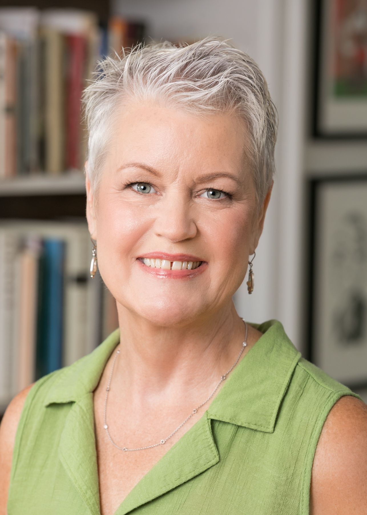 Photo of a smiling Beth Ann Bryant-Richards wearing a green top in front of a bookcase.